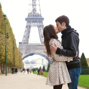 Young romantic couple kissing near the Eiffel Tower in Paris